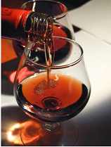 pouring cognac into a brandy snifter