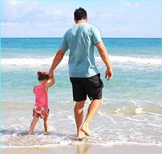 dad walking with daughter on the beach