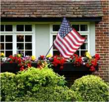 US flag flying outside a suburban house